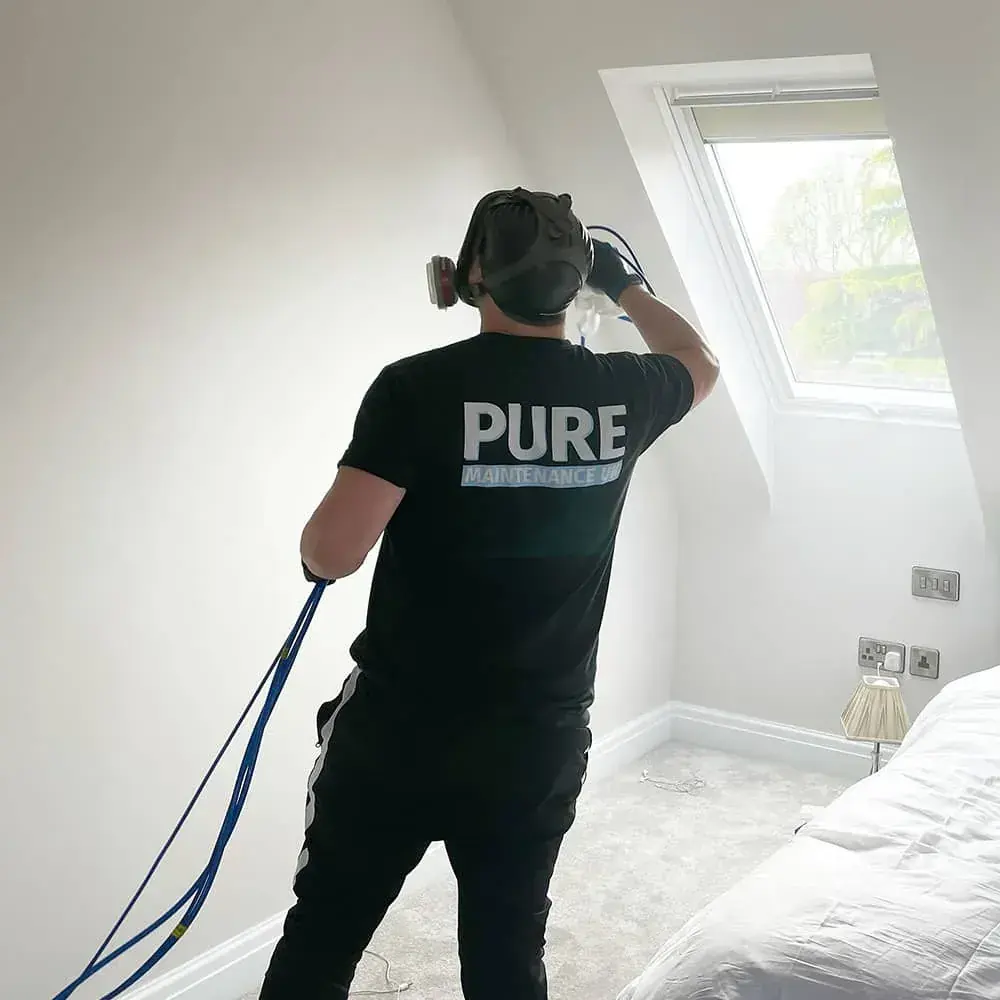 A technician applying EverPURE to a bedroom wall